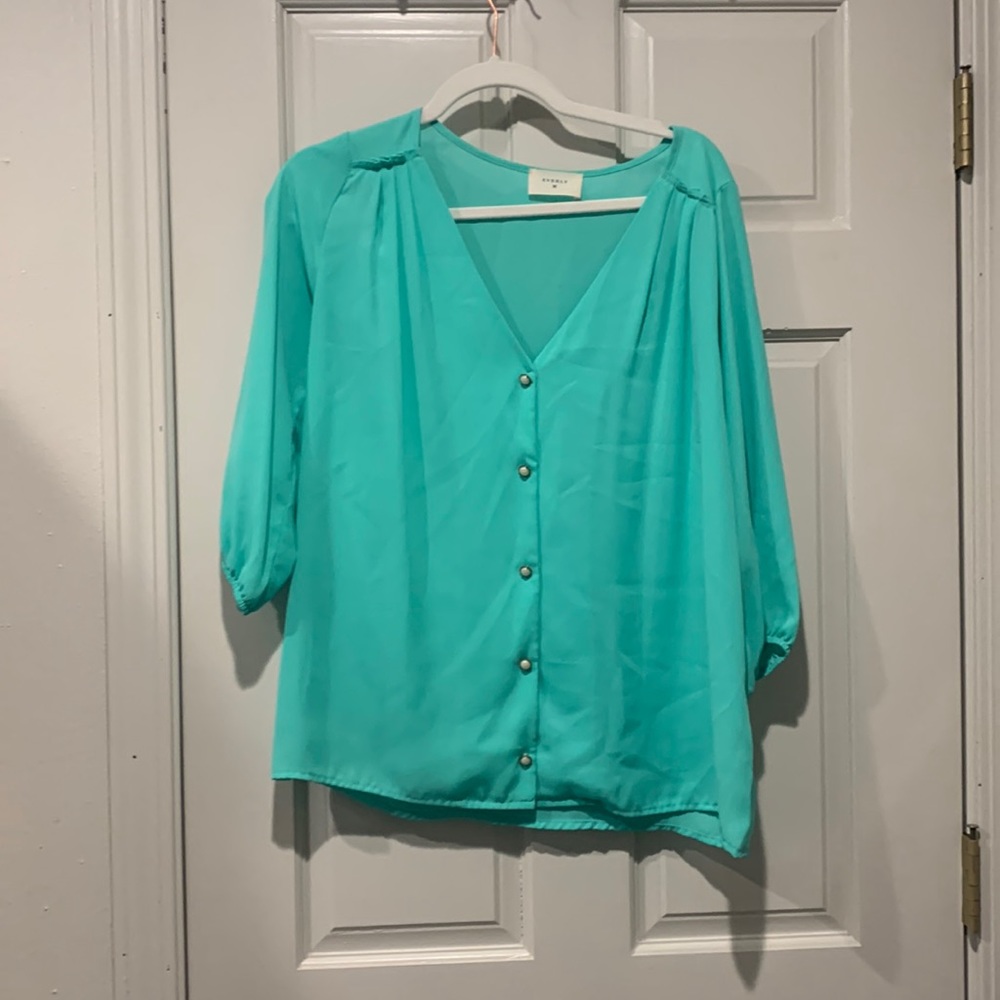 Turquoise blouse with faux pearl buttons. Size medium. Never worn